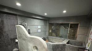 A modern bathroom with a large bathtub, a shower area, and a toilet.