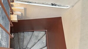 A spiral staircase with wooden steps and metal railings, leading to an upper floor. - Cosy Studio Saint Lazare (Paris)