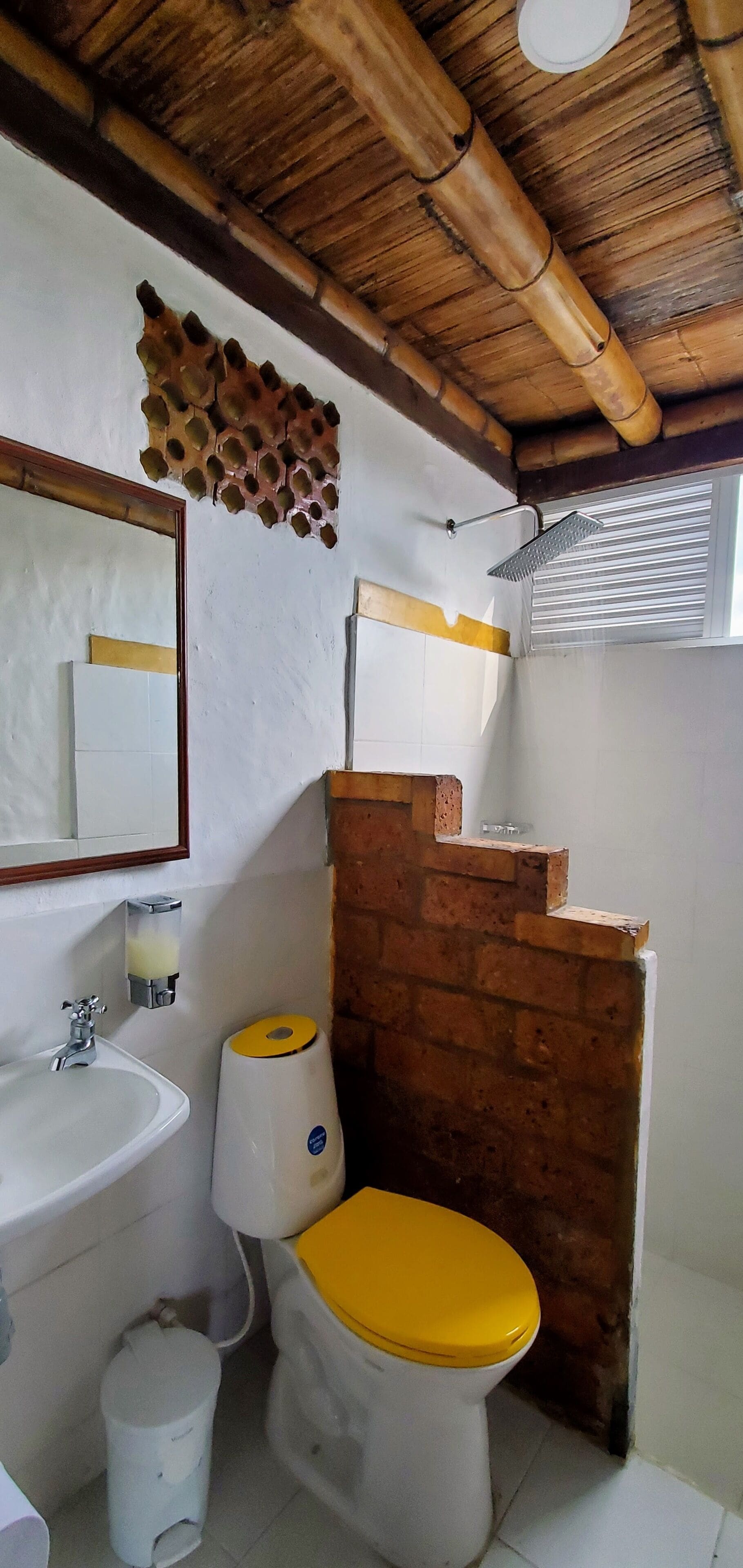 Une salle de bain avec des toilettes, un lavabo et une douche.
