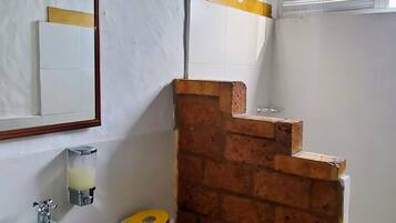 Un baño con inodoro, lavamanos y ducha.