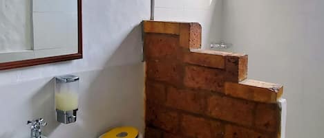 Een badkamer met toilet, wastafel en douche.
