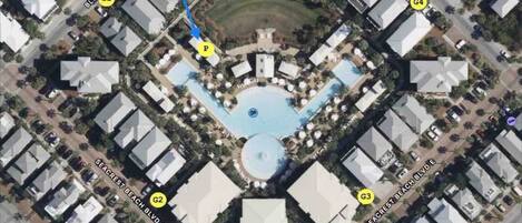 An aerial view of a hotel with a central pool, guest services, and multiple guest rooms.