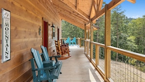 Eine Holzterrasse mit Adirondack-Stühlen und einem Schild, auf dem steht: 'Entspannen, Sie sind in den Bergen'.