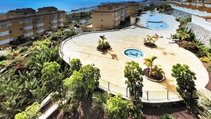 A resort with a central pool, surrounded by lush greenery and multiple buildings.
