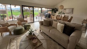 Ein geräumiges Wohnzimmer mit einer großen Couch, Sesseln und einem Essbereich.