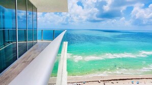A modern building with large glass windows overlooking a beach with clear turquoise waters and a sandy shore. - HYDE 3BR OceanFront Suite w SunriseTo Sunset Views (Hollywood)