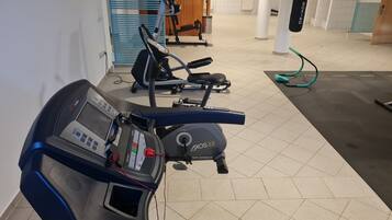 A gym with cardio equipment including a treadmill and an elliptical machine.