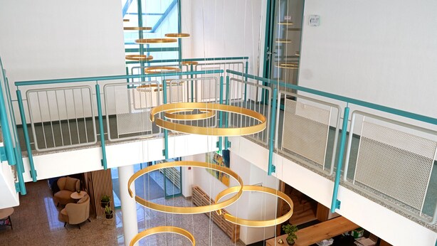 A multi-level interior with a central spiral staircase, open-plan seating areas, and a modern chandelier. - Hotel Bessunger Forst (Rossdorf)