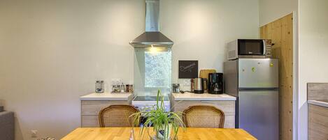 A modern kitchen with a central island, a built-in microwave, and a stainless steel refrigerator.