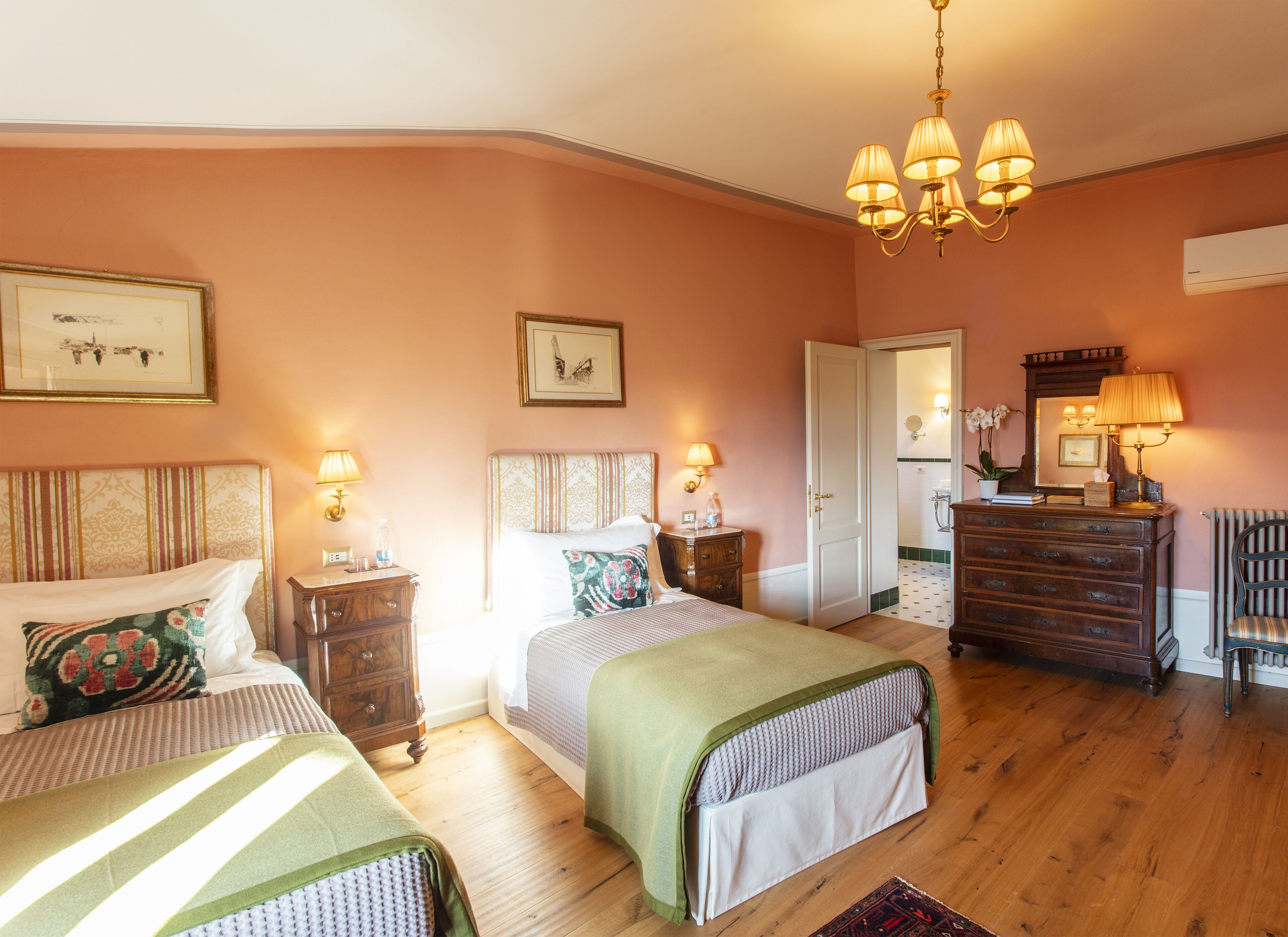 A bedroom with two beds, a dresser, a chair, and a mirror.