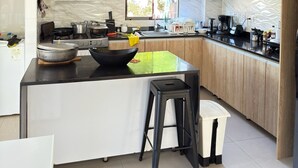 Una cocina moderna con una isla central, armarios de madera y un ventanal que proporciona luz natural.