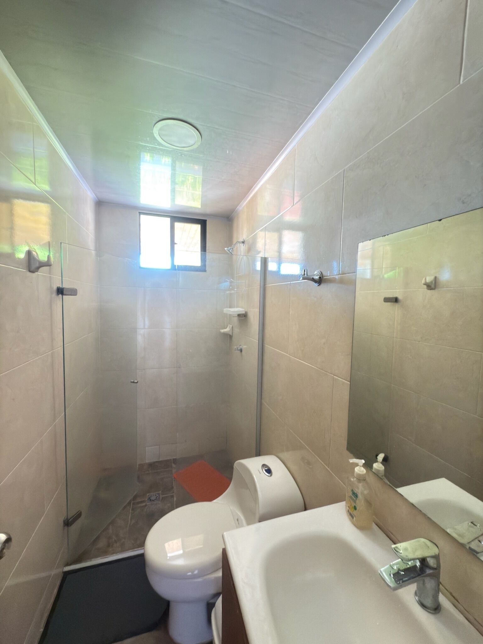 Un baño con ducha, inodoro y lavamanos.
