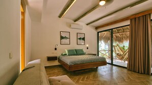 A bedroom with a bed, a bench, a nightstand, and a large window. - Cozy Jungle Retreat, Private Indoor Pool, Breakfast, 5 mins to the Beach (San Miguel de Cozumel)