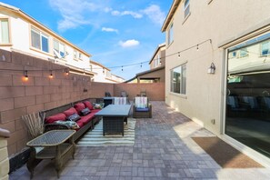 Un patio al aire libre con un conjunto de sofás, sillas y una mesa.