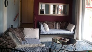 A living room with a sofa, a coffee table, and a mirror. - #4 Casa Galarza (Cabo Rojo)