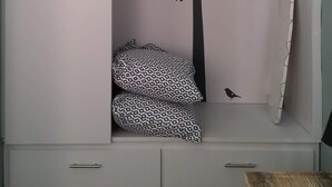 A wardrobe with a tree decal, patterned pillows, and a wooden table. - #4 Casa Galarza (Cabo Rojo)