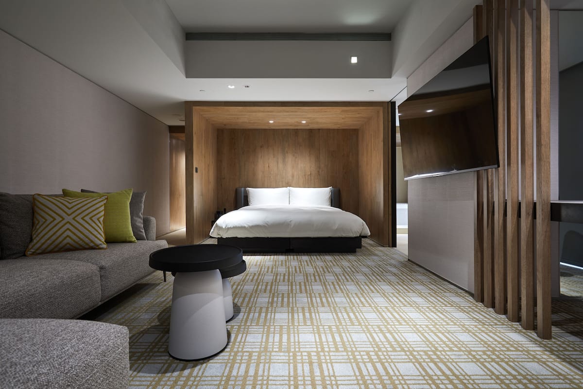 Une chambre à coucher moderne avec un lit, un canapé et une petite table.