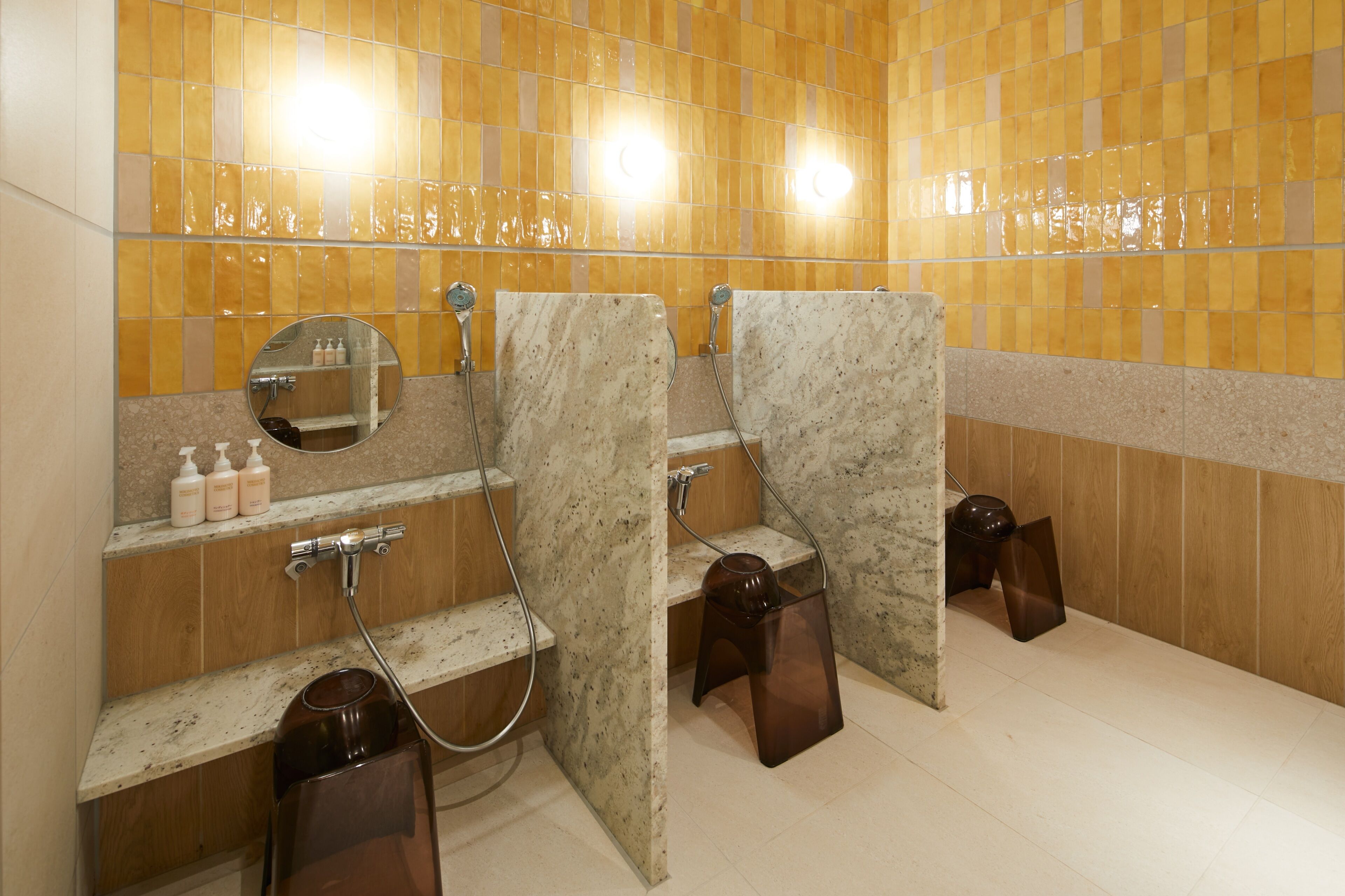 A bathroom with two sinks, a mirror, and a shelf with toiletries.