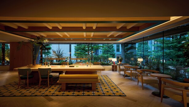 A modern indoor space with a wooden ceiling, a central dining table, and surrounding seating. - The Royal Park Hotel Ginza 6-chome (Tokyo)