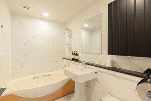 A modern bathroom with a bathtub, a sink, and a mirror. - Oceanpalade Hotel and Resort (Jeju City)