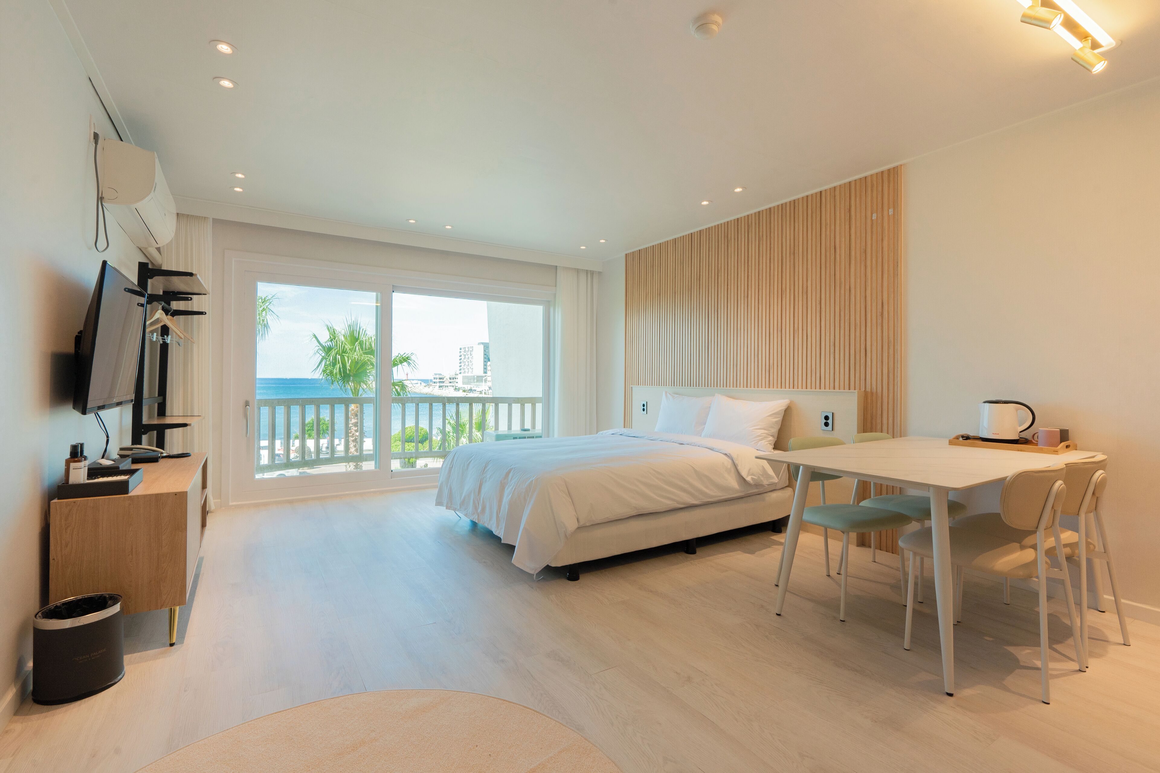 Ein modernes Hotelzimmer mit Bett, Schreibtisch und Meerblick.