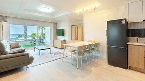 Une cuisine moderne avec un coin repas, un canapé et une vue sur l’extérieur.