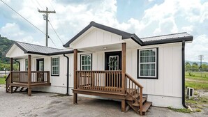 A small, single-story building with a porch and a staircase leading to a door.