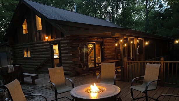 A rustic log cabin with a deck, outdoor seating, and a central fire pit. - LABOR DAY SALE-Private Trillium Lake Log Cabin-Sauna & Nature Escape (Hackensack)