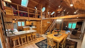 A rustic cabin interior with a kitchen, dining area, and a loft bedroom. - LABOR DAY SALE-Private Trillium Lake Log Cabin-Sauna & Nature Escape (Hackensack)