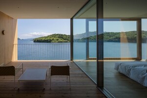 Un balcón con vistas a un lago y una isla boscosa.