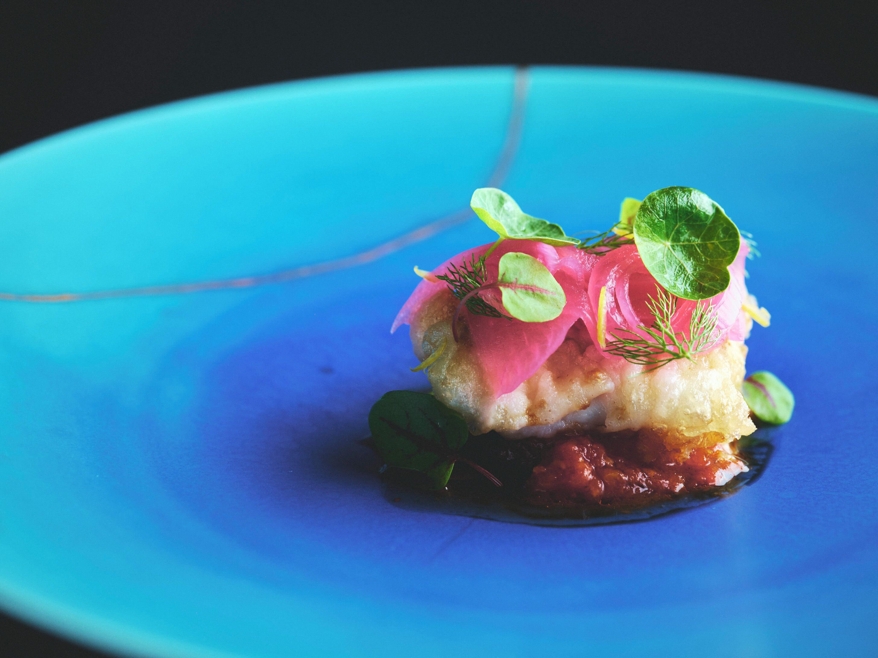 A blue plate with a dish of food.