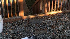 A wooden deck with a gravel pathway leading to a house. - Comfy 2 Bedroom 1 Bath Near Sand Lake and Airport (Anchorage)