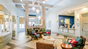 A spacious lobby with a reception desk, seating area with chairs and a coffee table, and a fireplace. - Solterra Resort 6 bed home, 20 mins to Disney, 5 mins to Championsgate! (Davenport)