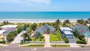 A residential area with a house in the foreground, a beach, and a clear sky. - Dream Beach Home Vacation - Direct Beach Access & Exquisite Waterfront Views (Cocoa Beach)