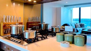 Una cocina moderna con estufa a gas, ollas, un bloque de cuchillos y vista al océano.