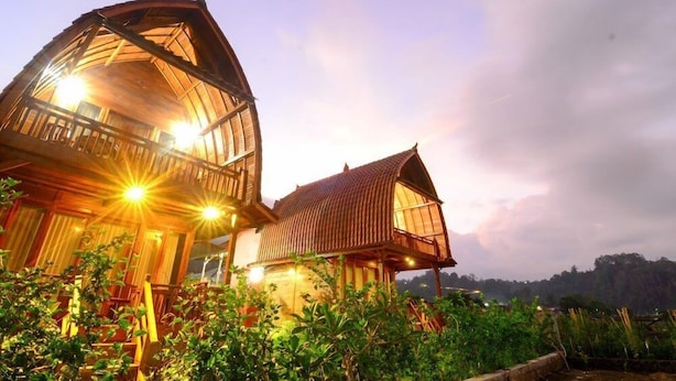 A large wooden house with a balcony and a smaller attached structure. - Villa Kedisan Lake View Kintamani (Kintamani)