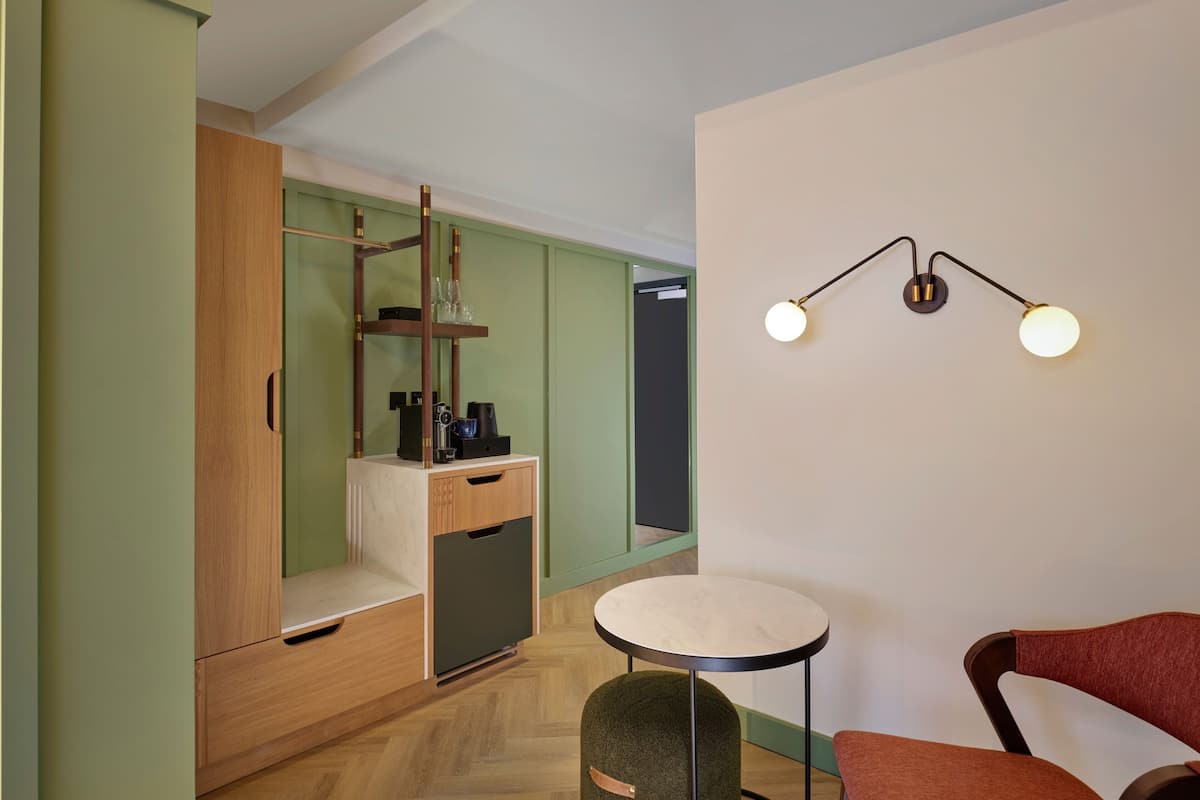 A compact room with a wooden wardrobe, a small table, and a chair.