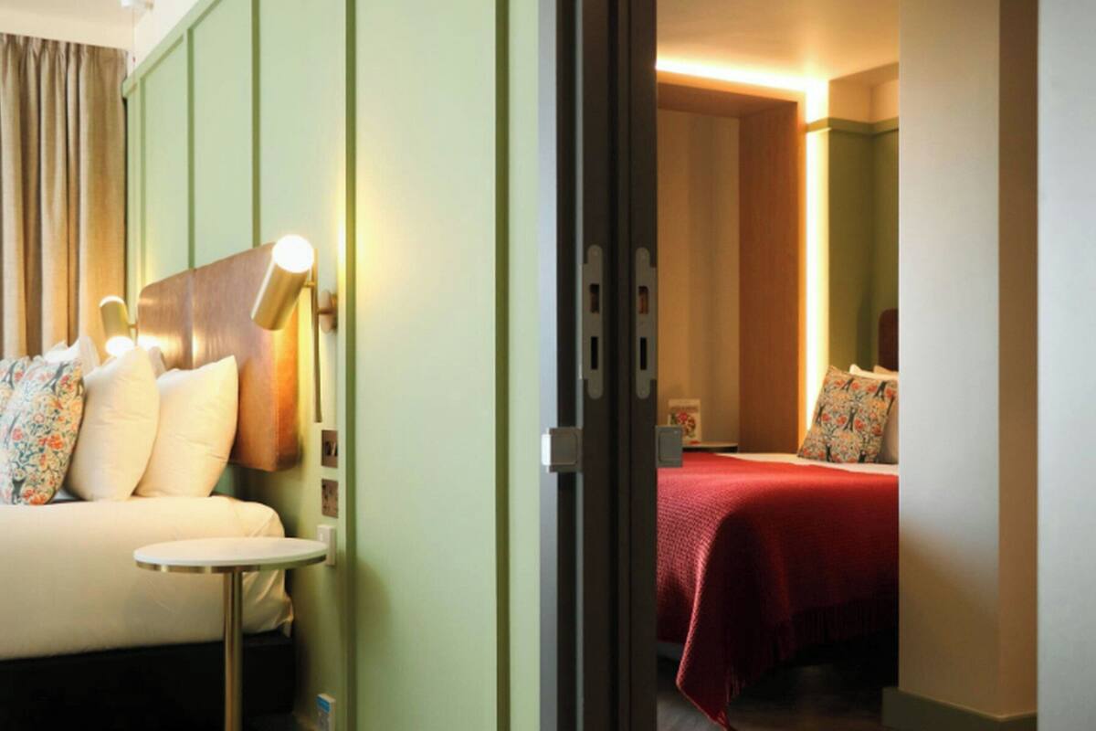 A hotel room with a bed, a bedside table, and a nightstand.