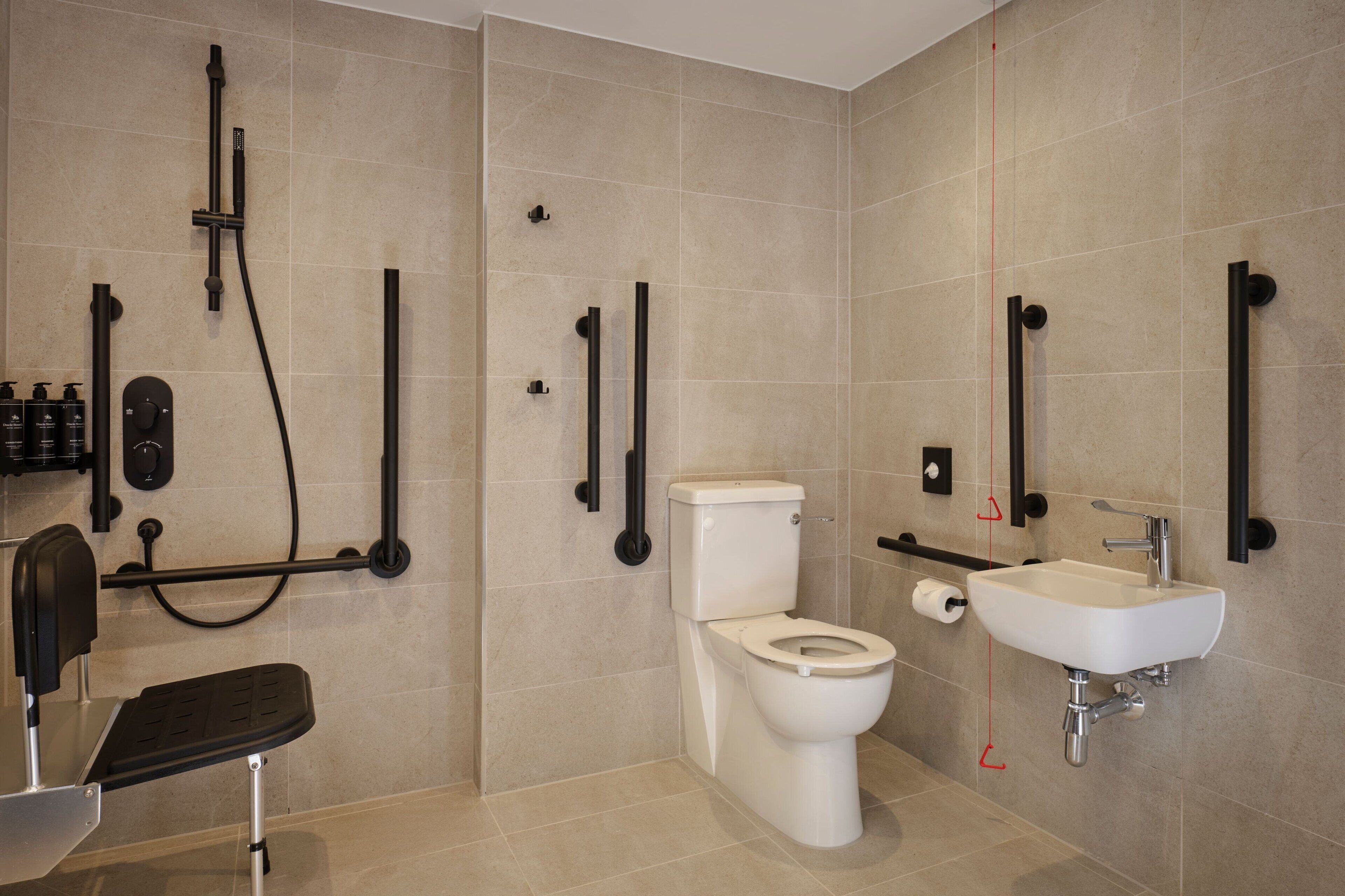 Et moderne badeværelse med toilet, vask og brusebad.