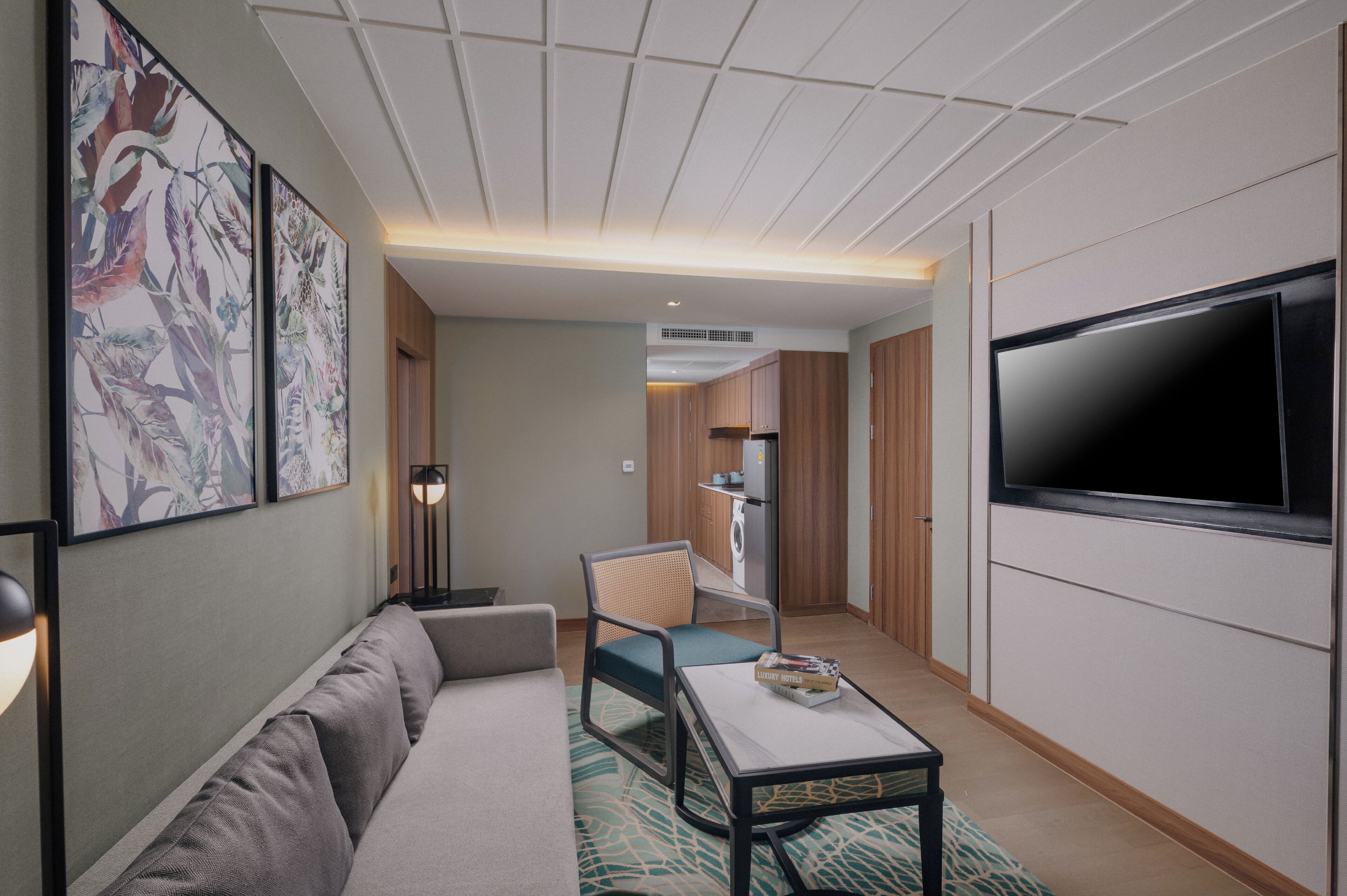 A modern living room with a sofa, a coffee table, a TV, and artwork on the wall.