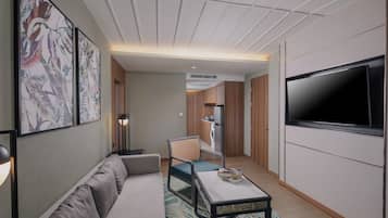 A modern living room with a sofa, a coffee table, a TV, and artwork on the wall.