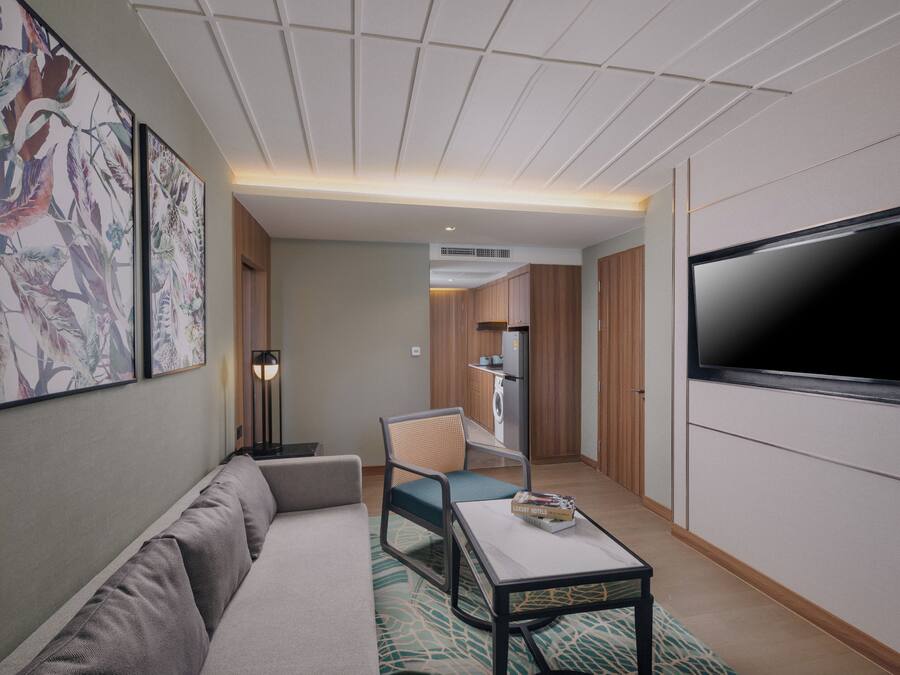 A modern living room with a sofa, a coffee table, a TV, and artwork on the wall.