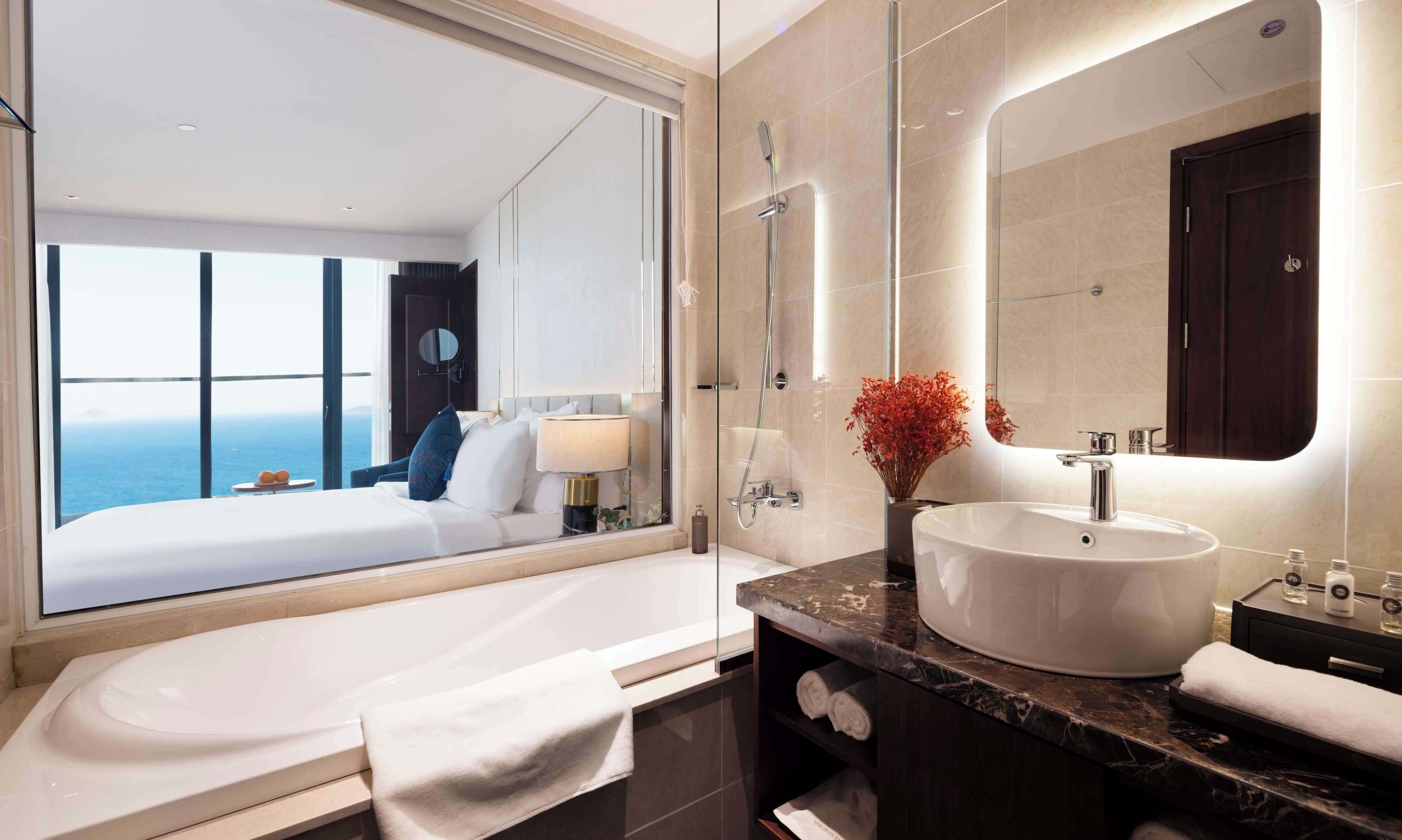 Un baño moderno con una bañera grande, un tocador con lavabo y un espejo amplio.