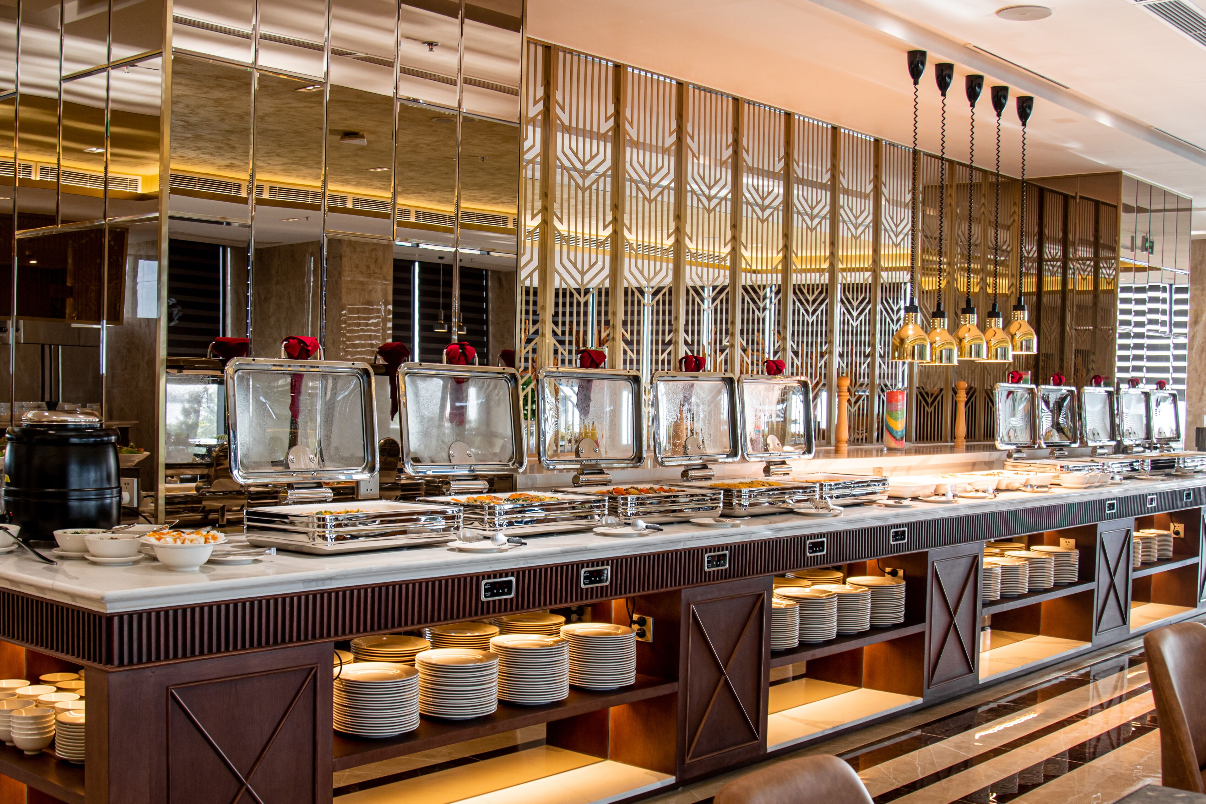 A buffet setup with multiple serving stations, a variety of dishes, and a modern interior design.