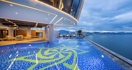 Una piscina al aire libre, sombrillas, sillones reclinables de piscina