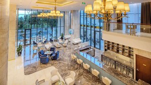 A spacious lobby with a marble floor, multiple seating areas, and a bar with a glass railing. - Best Western Premier Marvella Nha Trang (Nha Trang)