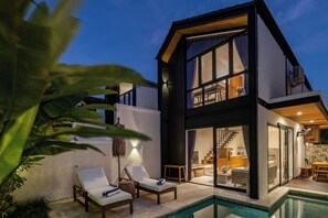 A modern two-story house with a pool, featuring a spacious living area, a staircase, and a kitchen. - Villa Isola Gallinara (Canggu)