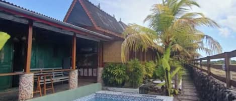 A swimming pool with a tiled edge, a wooden deck, and a stone wall.