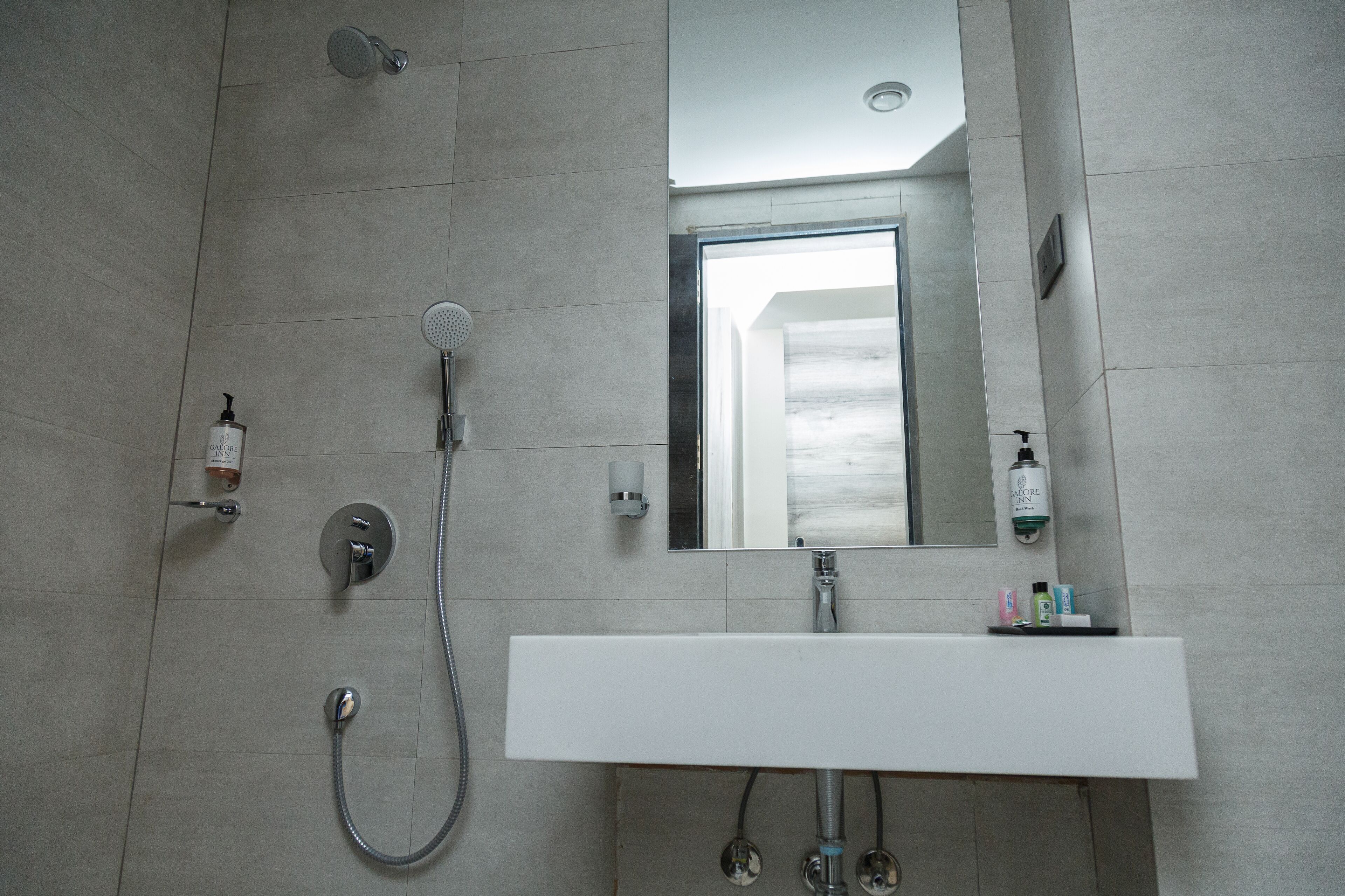 A modern bathroom with a shower, a sink, and a mirror.