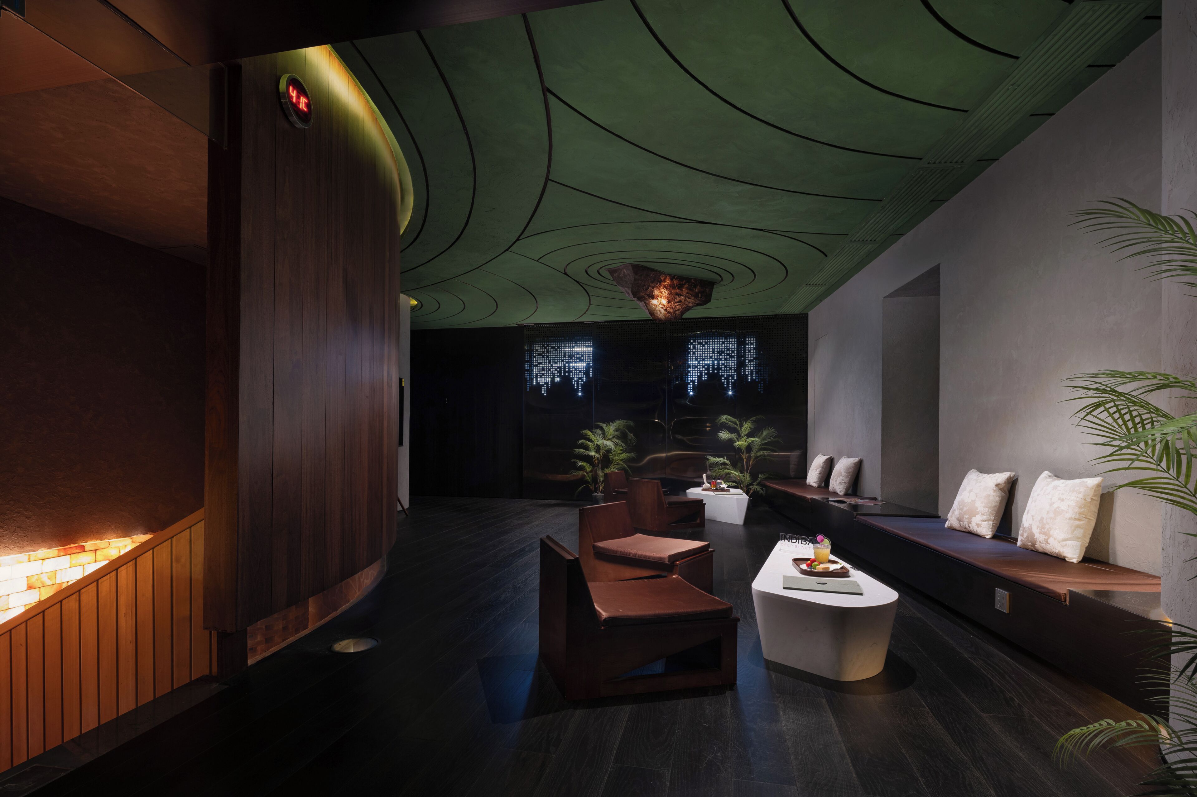 A modern interior with a curved ceiling, seating area, and a digital display.